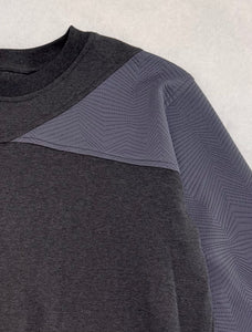 Gray sweatshirt with textured shoulder panels on a light gray background
