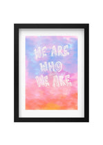 Framed artwork with 'We are who we are' text on a colorful watercolor background